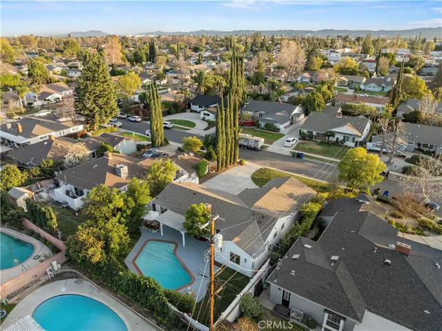 an aerial view of a house with a yard and large tree