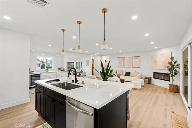 a kitchen with stainless steel appliances kitchen island granite countertop a sink a stove and a wooden floors