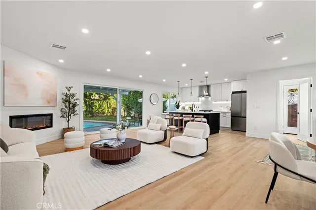 a living room with furniture a fireplace and a kitchen view