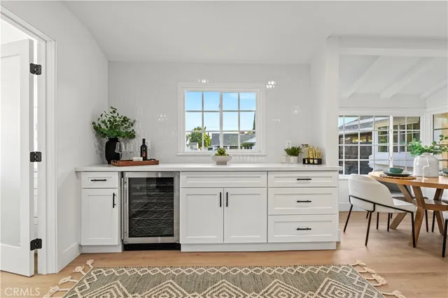 a kitchen with white cabinets and sink