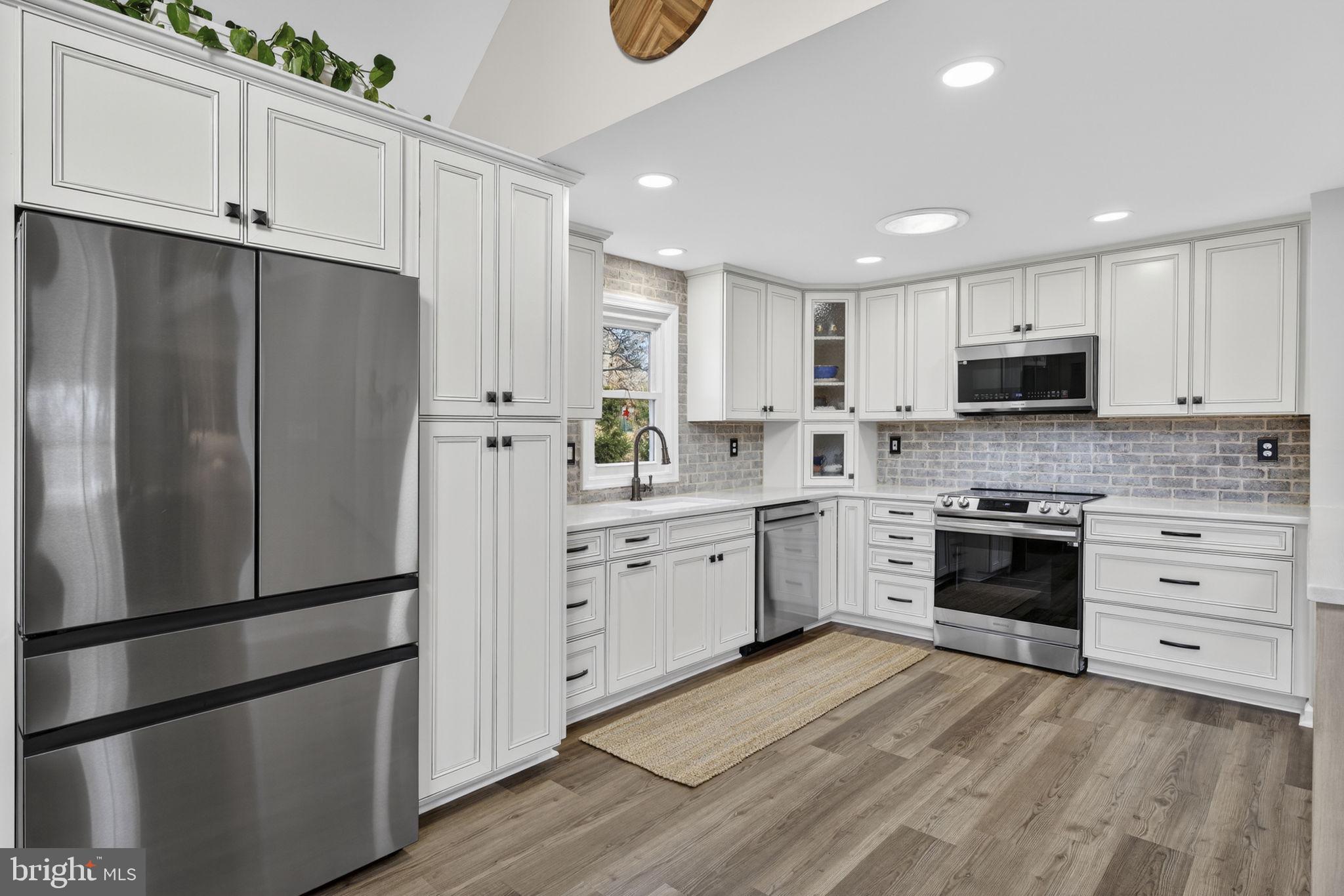 9666 Springs Road Warrenton, VA 20186 - Photo 25 of 77 a kitchen with white cabinets and stainless steel appliances