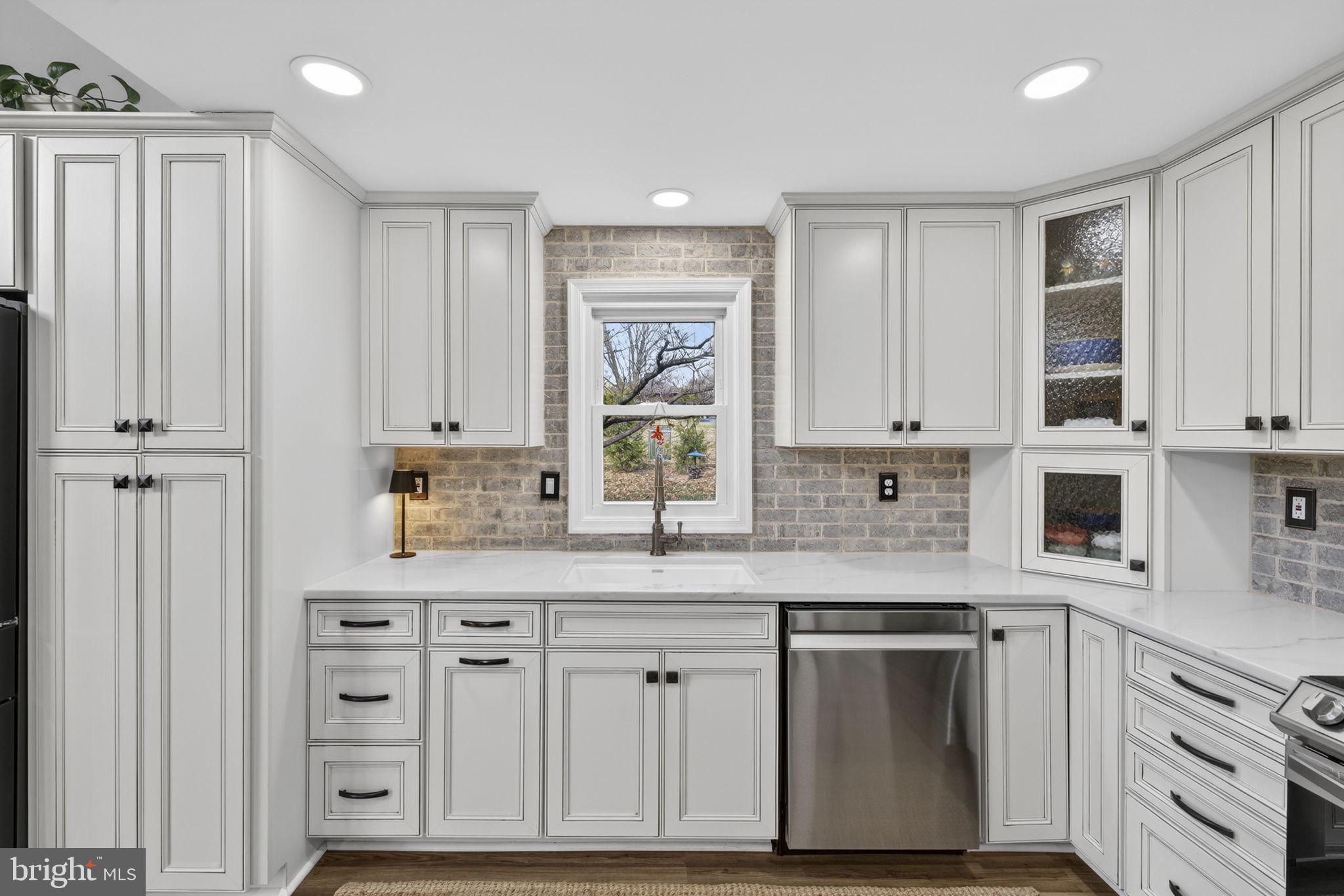 9666 Springs Road Warrenton, VA 20186 - Photo 28 of 77 a kitchen with stainless steel appliances granite countertop a sink and cabinets with wooden floor