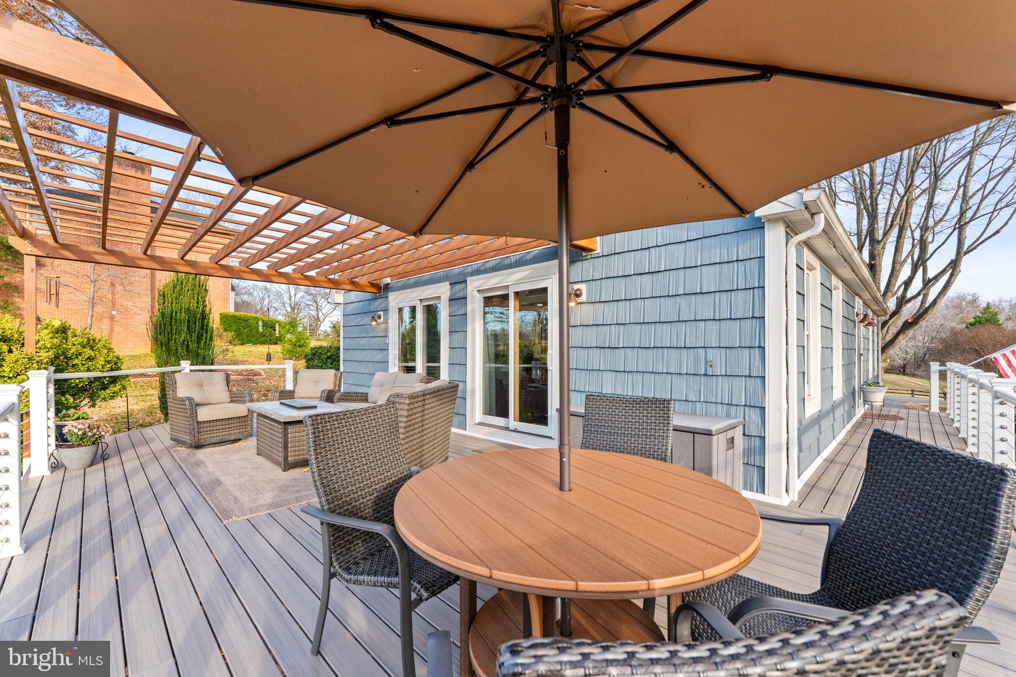 9666 Springs Road Warrenton, VA 20186 - Photo 63 of 77 a view of a patio with table and chairs under an umbrella