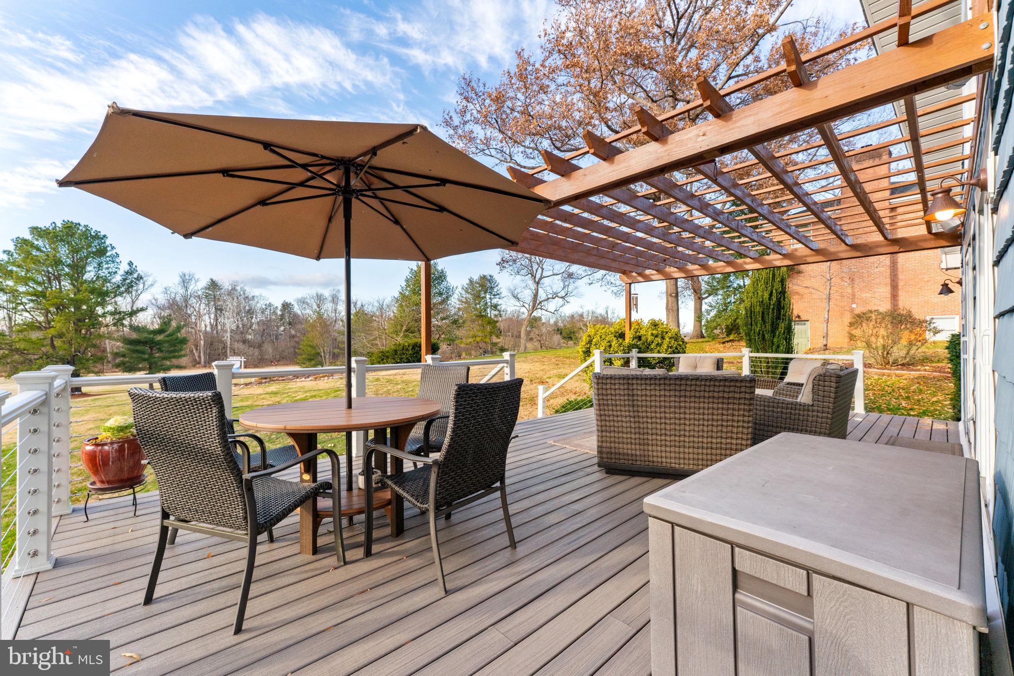 9666 Springs Road Warrenton, VA 20186 - Photo 65 of 77 a view of a patio with table and chairs under an umbrella with a barbeque