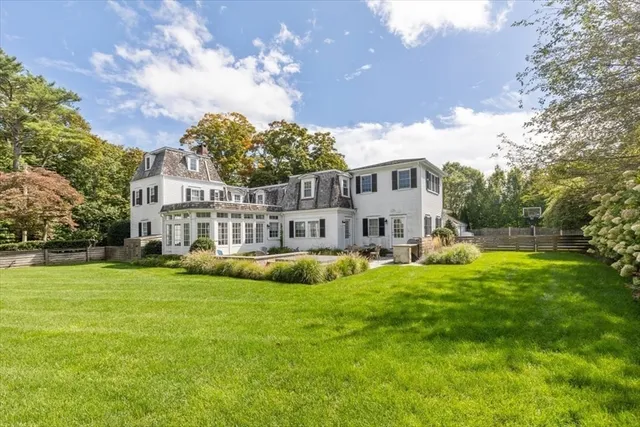 a view of a house with a big yard and large trees