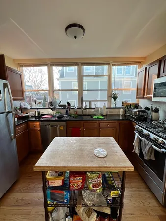 a kitchen with a stove a sink a microwave a dining table and chairs