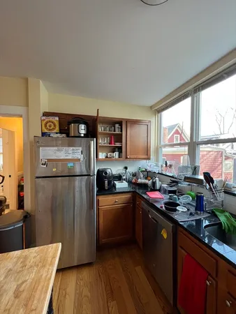 a kitchen with a refrigerator a sink dishwasher stove and wooden floor