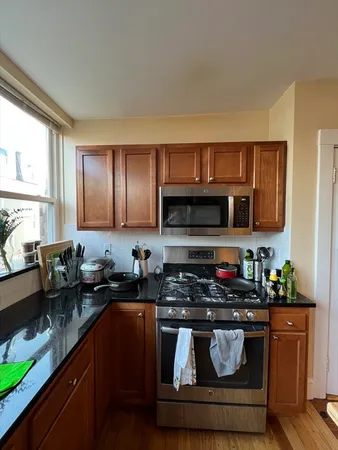 a kitchen with stainless steel appliances granite countertop a sink stove and cabinets