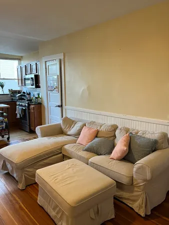 a living room with couches and a kitchen view
