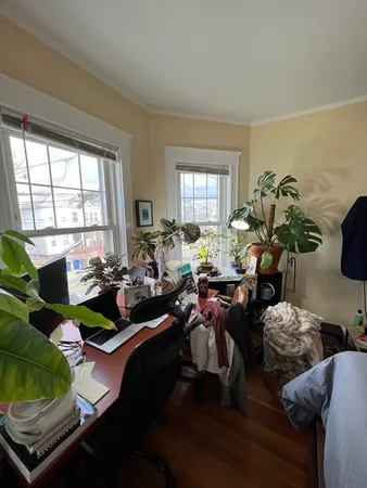 a living room filled with furniture hard wood floor and a floor to ceiling window
