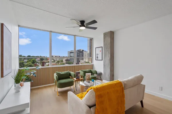 a living room with furniture a chandelier and a floor to ceiling window