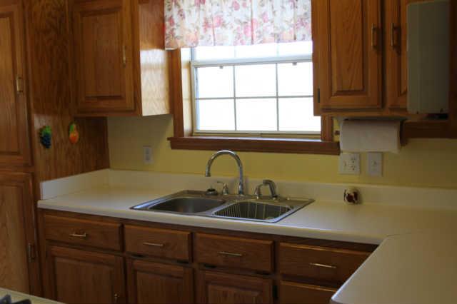 101 Maple Street Adams, TN 37010 - Photo 5 of 15 The galley kitchen is equipped with a gas range, dishwasher, refrigerator and microwave. Though not oversized, it is conveniently designed for efficient use and storage. The window overlooks the beautiful rear lawn.