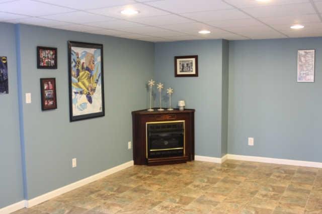 101 Maple Street Adams, TN 37010 - Photo 7 of 15 The corner fireplace offers a focal point for an additional sitting area in the downstairs den. Bright sunny windows allow the space to be flooded with natural light. The downstairs space offers opportunity for a home office or flex room.