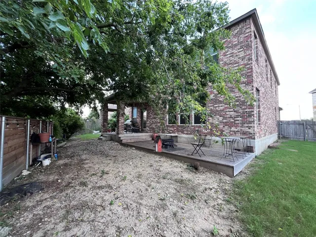 a view of a big yard in front of a house with a large tree