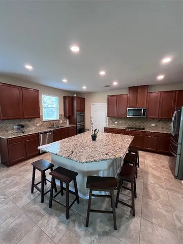 a large kitchen with a table and chairs