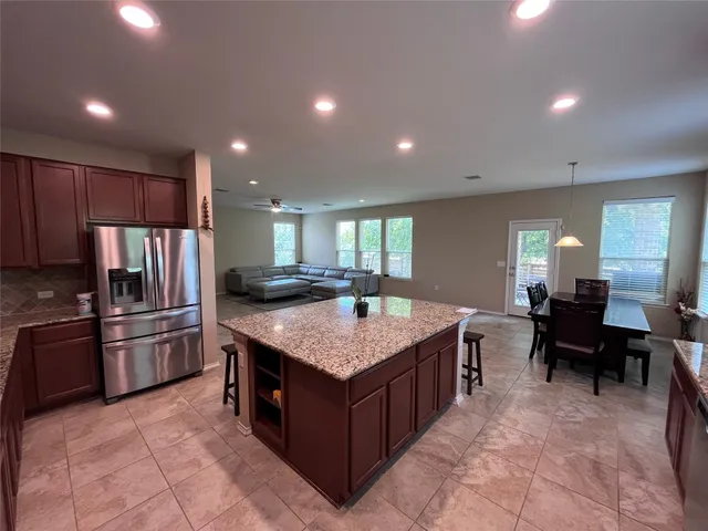 a kitchen with stainless steel appliances granite countertop a stove top oven a refrigerator a sink and dishwasher