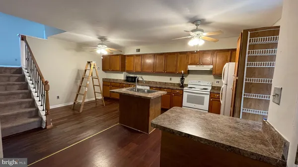 a kitchen with granite countertop a stove top oven and cabinets