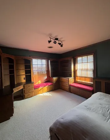 a bedroom with furniture and a large window