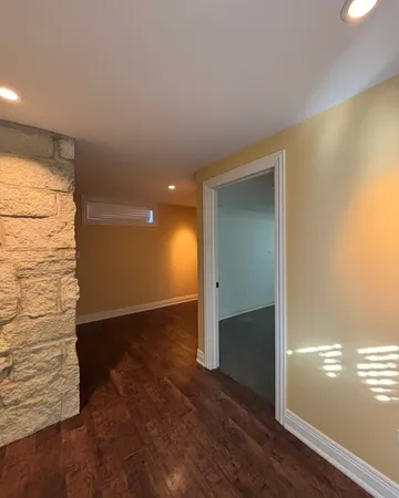 a view of empty room with wooden floor