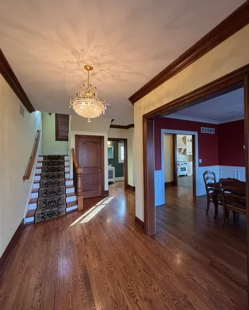 a view of a room with wooden floor clock and stairs
