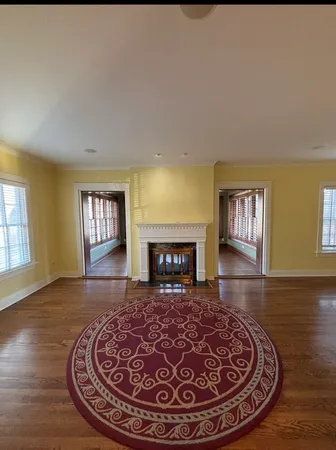 a view of a livingroom with wooden floor and a fireplace