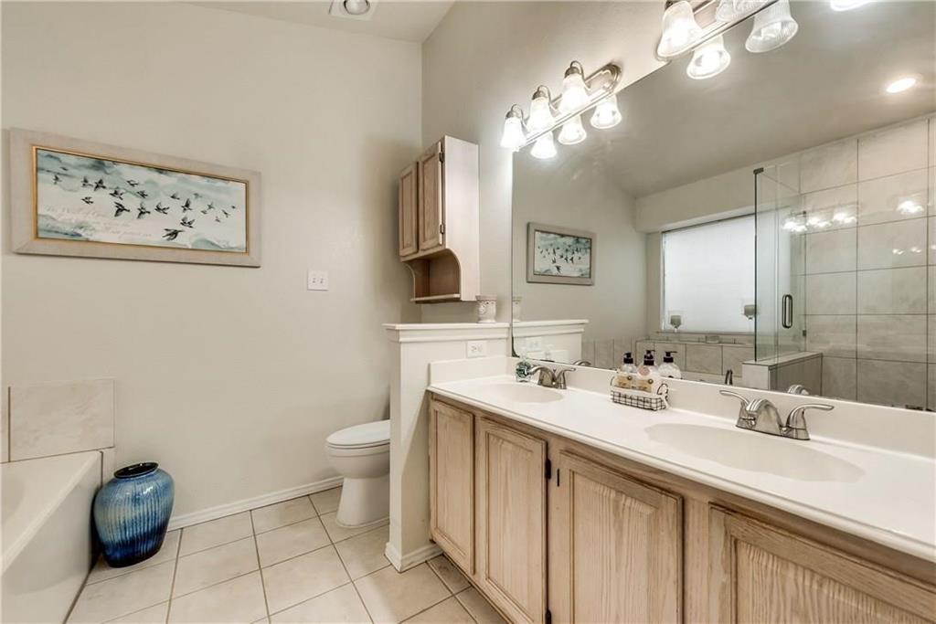 2114 Carnation Court Garland, TX 75040 - Photo 4 of 6 a bathroom with a sink a toilet and a mirror