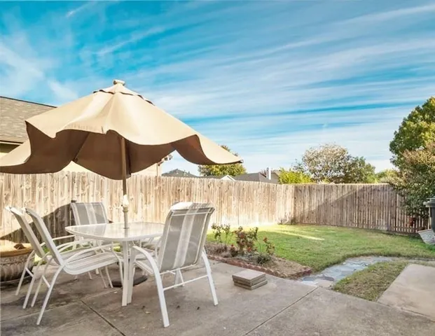 a view of a chairs and table in the backyard