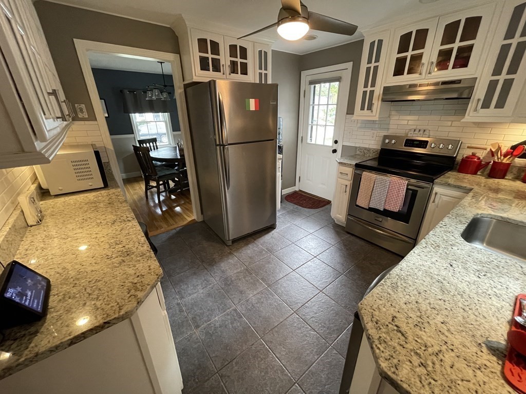 22 Westbrook Road Worcester, MA 01602 - Photo 16 of 39 a kitchen with granite countertop a refrigerator and a stove top oven