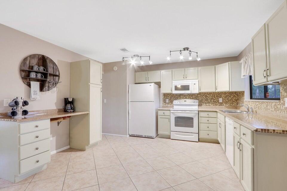 1258 Southeast Rickenbacker Terrace Port St. Lucie, FL 34952 - Photo 11 of 29 a kitchen with granite countertop a refrigerator oven a sink and cabinets