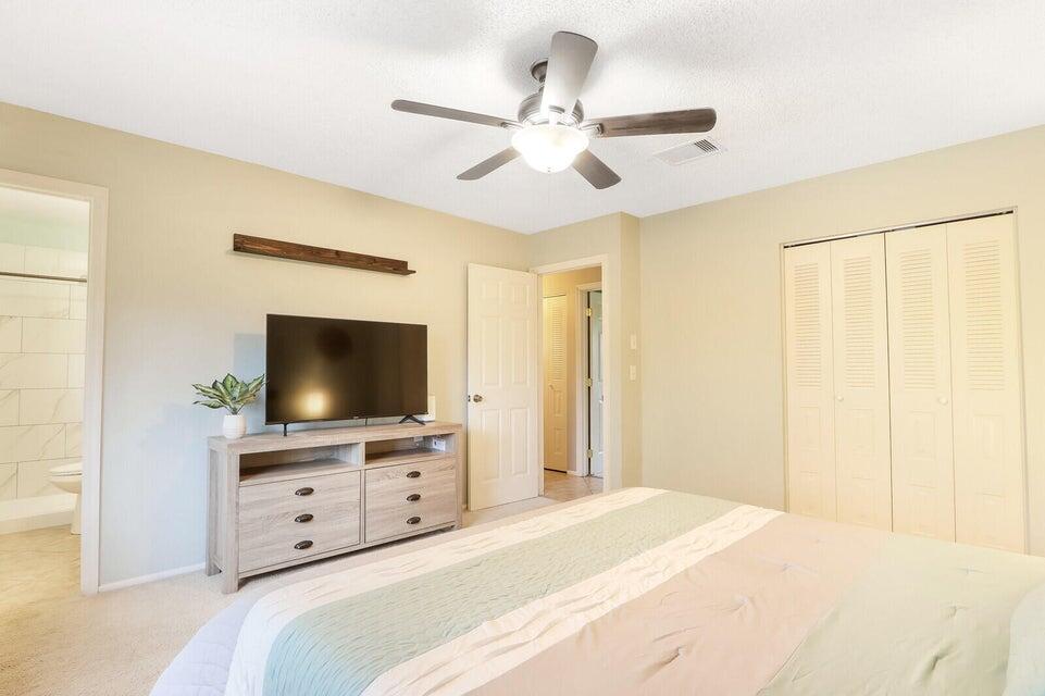 1258 Southeast Rickenbacker Terrace Port St. Lucie, FL 34952 - Photo 15 of 29 a bedroom with a bed and a flat tv screen on dresser