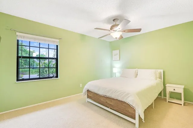 a bedroom with a bed and a ceiling fan