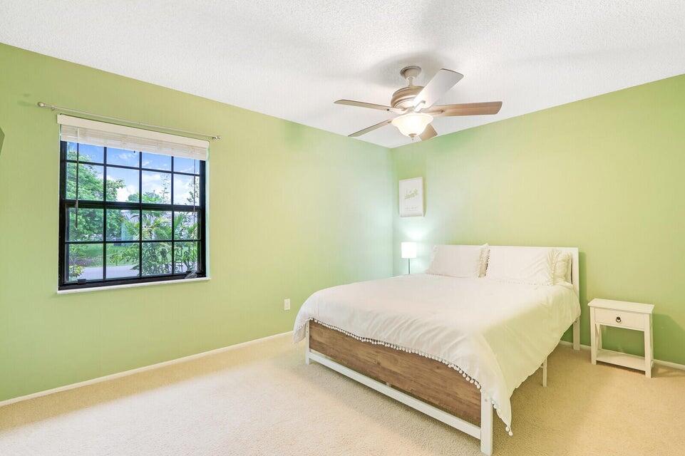 1258 Southeast Rickenbacker Terrace Port St. Lucie, FL 34952 - Photo 17 of 29 a bedroom with a bed and a ceiling fan