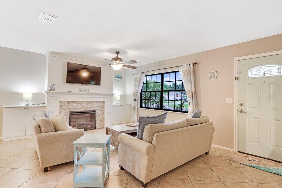 1258 Southeast Rickenbacker Terrace Port St. Lucie, FL 34952 - Photo 2 of 29 a living room with furniture a fireplace and a flat screen tv