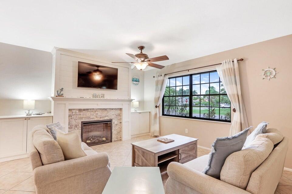 1258 Southeast Rickenbacker Terrace Port St. Lucie, FL 34952 - Photo 6 of 29 a living room with furniture a fireplace and a flat screen tv