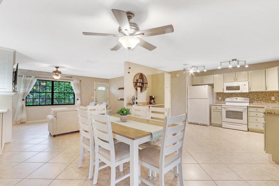 1258 Southeast Rickenbacker Terrace Port St. Lucie, FL 34952 - Photo 8 of 29 a dining room with kitchen island stainless steel appliances furniture a chandelier and a view of kitchen