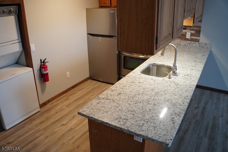 a kitchen with kitchen island a sink wooden floor and a refrigerator