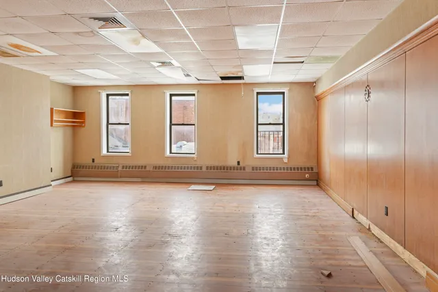 a view of a hallway with wooden floor and closet