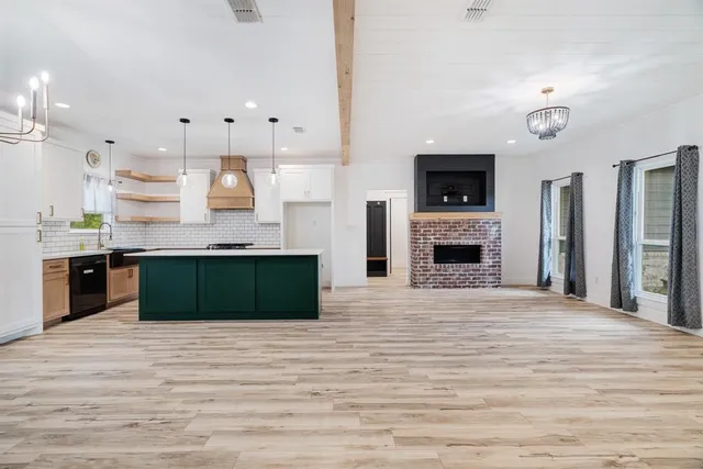 a large kitchen with cabinets and a wooden floor
