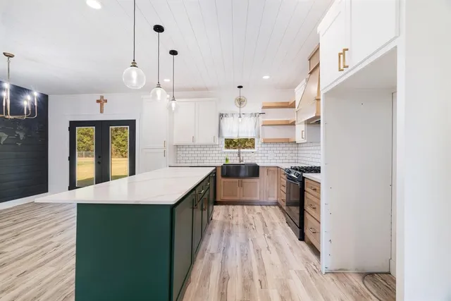 a kitchen with stainless steel appliances granite countertop a refrigerator a oven and a wooden floors