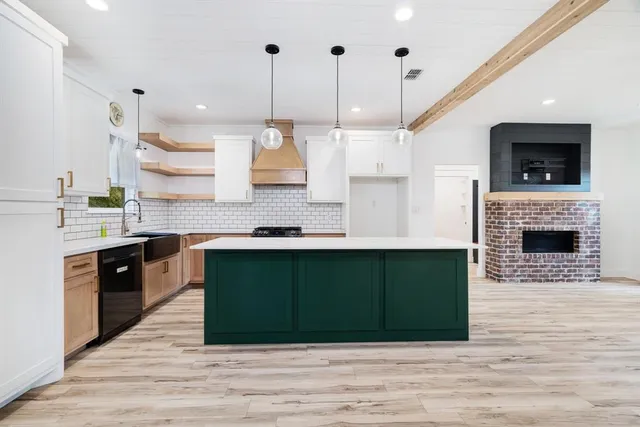 a kitchen with kitchen island a sink stove and wooden floor