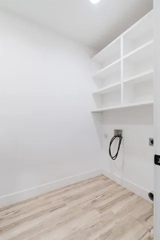 a view of a kitchen with kitchen island wooden floor stainless steel appliances and cabinets