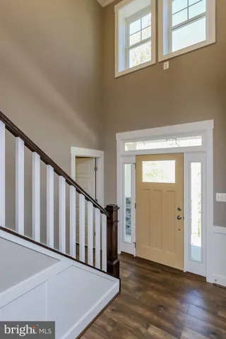 a view of a hallway with wooden floor and stairs