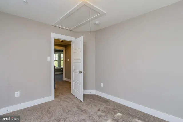an empty room and a bathroom with sink
