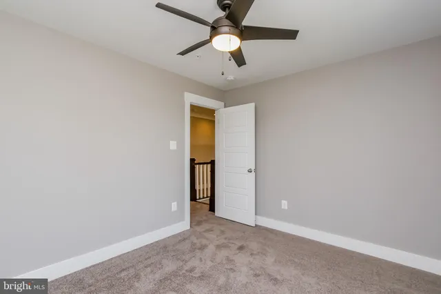 an empty room with closet and a chandelier fan