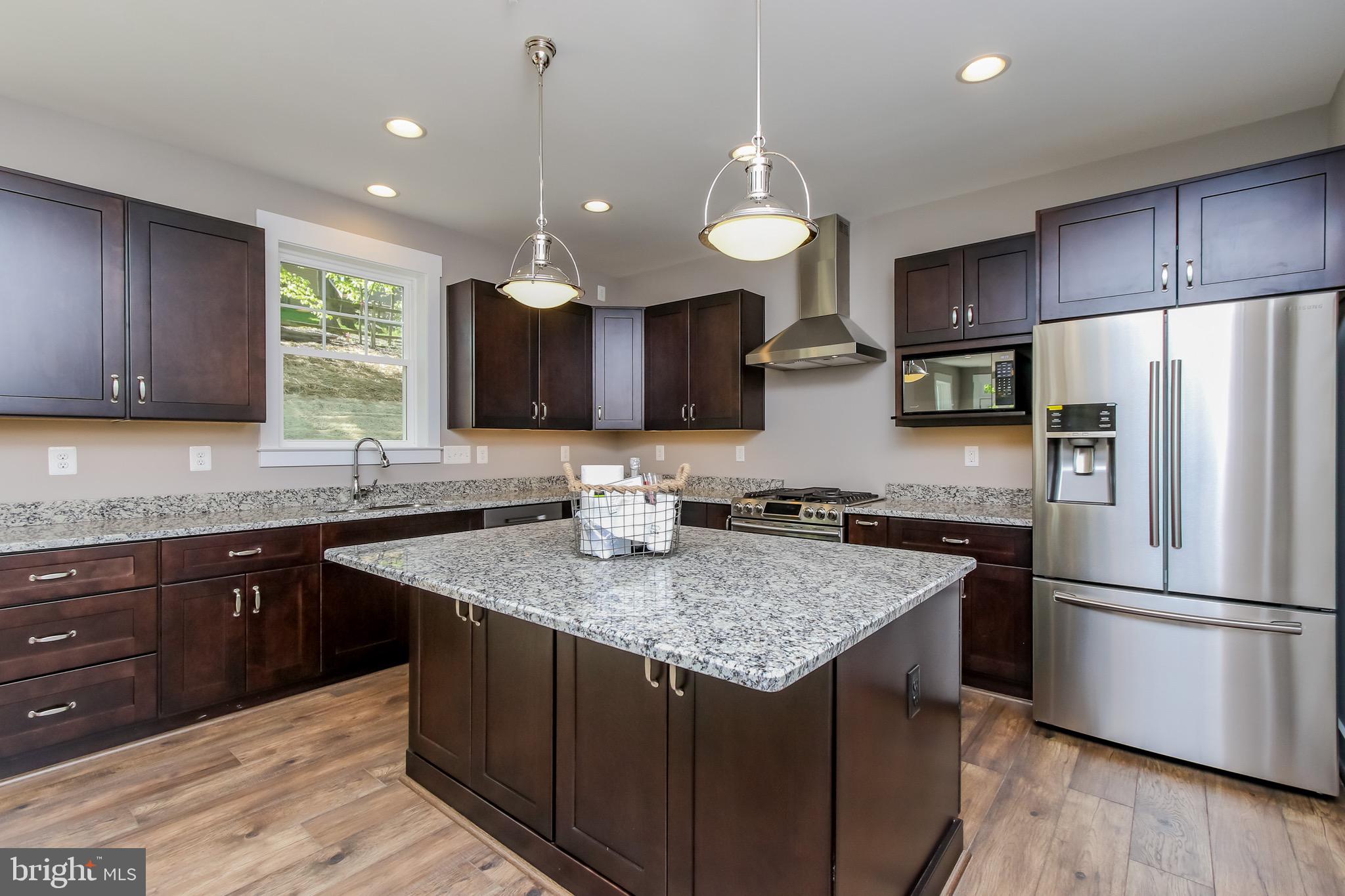 6346 Zittlestown Road Boonsboro, MD 21713 - Photo 4 of 27 a kitchen with a refrigerator a sink and wooden cabinets
