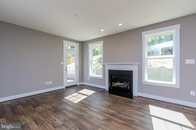 a view of an empty room with window and fire place