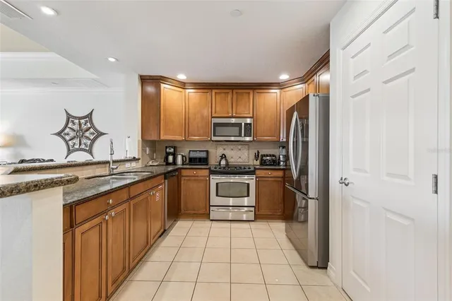 a kitchen with stainless steel appliances granite countertop a refrigerator and a stove top oven