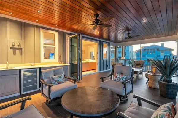 a living room with furniture a wooden floor and ceiling fan