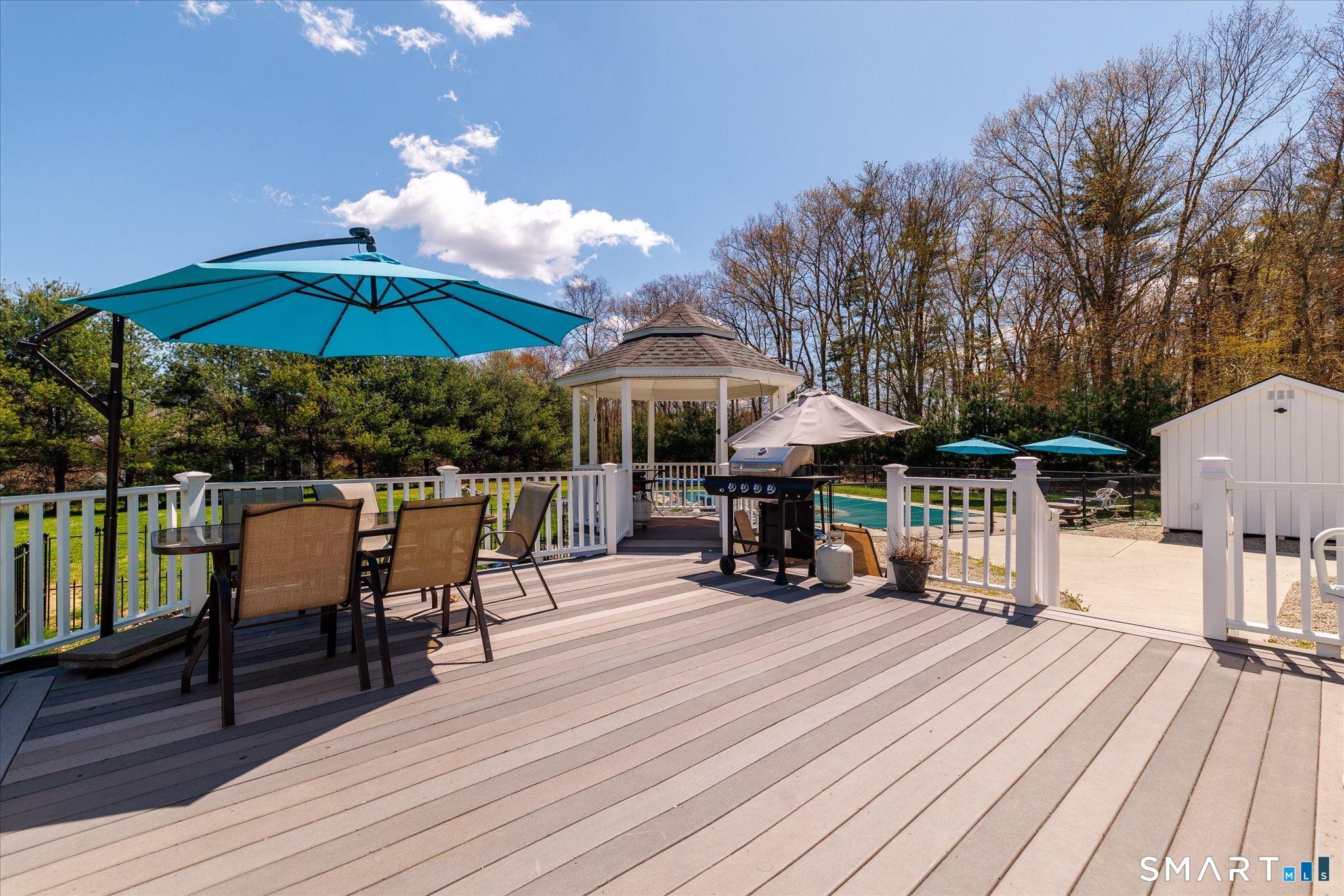 316 Allen Hill Road Brooklyn, CT 06234 - Photo 11 of 40 a view of a roof deck with table and chairs under an umbrella with wooden floor