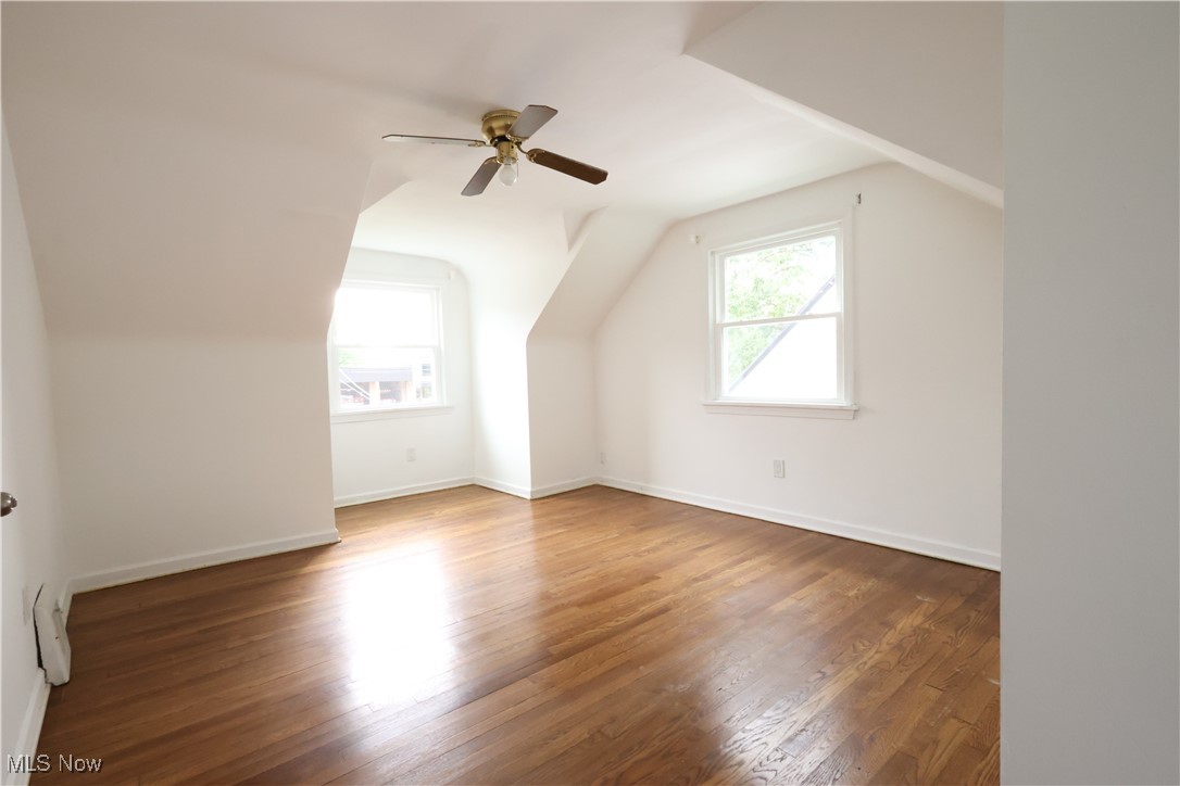 1332 South Green Road South Euclid, OH 44121 - Photo 13 of 23 Additional living space with healthy amount of natural light, wood finished floors, lofted ceiling, a ceiling fan, and a baseboard heating unit